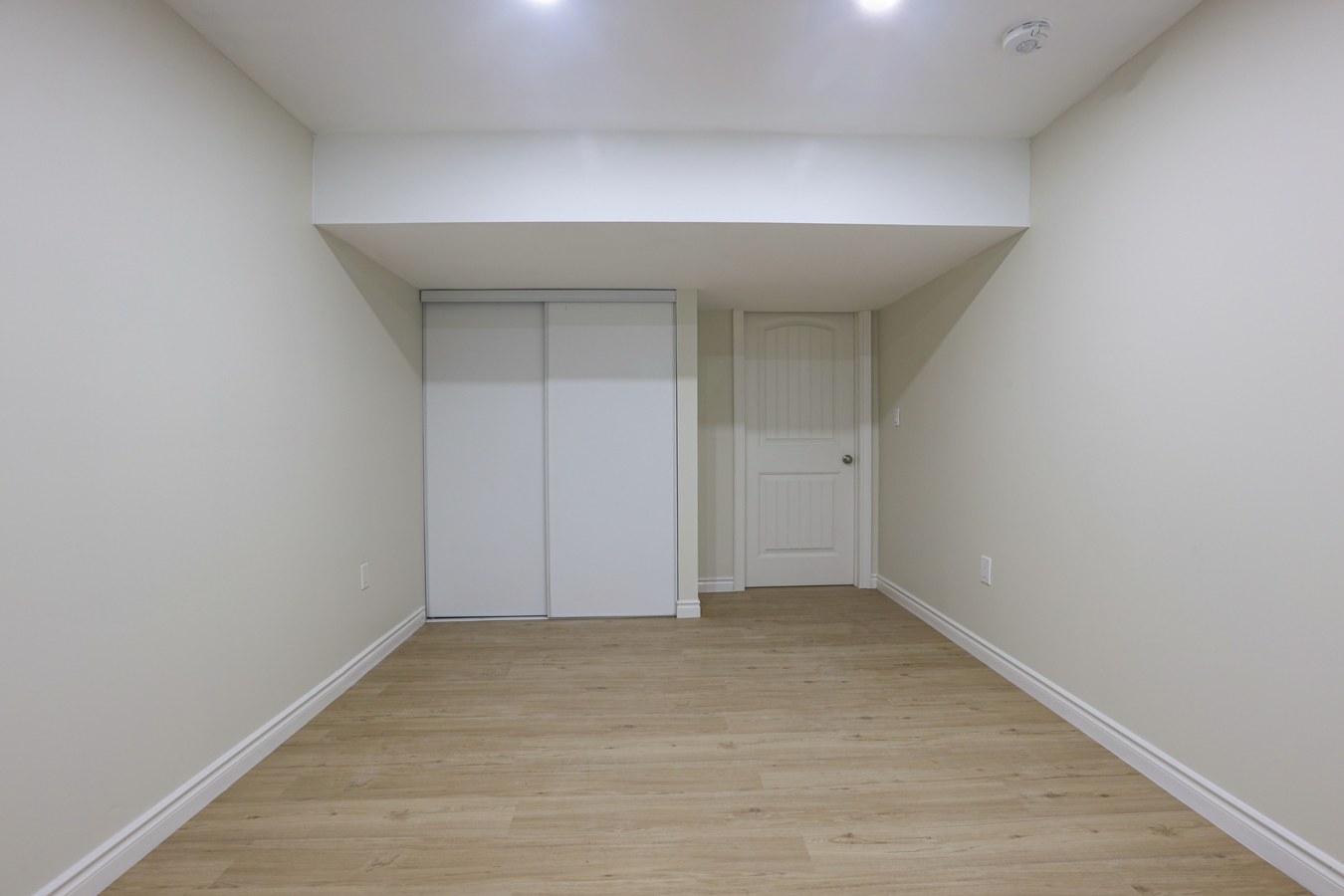 Finished basement renovation with laminate flooring and built-in closet